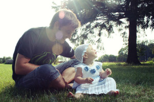 Photo of a man and a little girl sitting down on the grass
