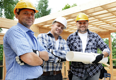 Photo of three men on a construction site wearing hard hats
