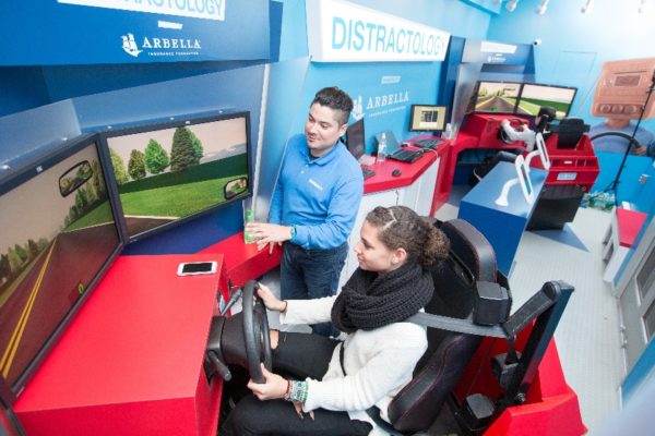 Photo of two people using a driving simulator