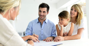 Photo of a young family going over documents with an independent agent