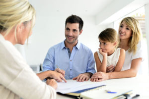 Photo of a young family going over documents with an independent agent